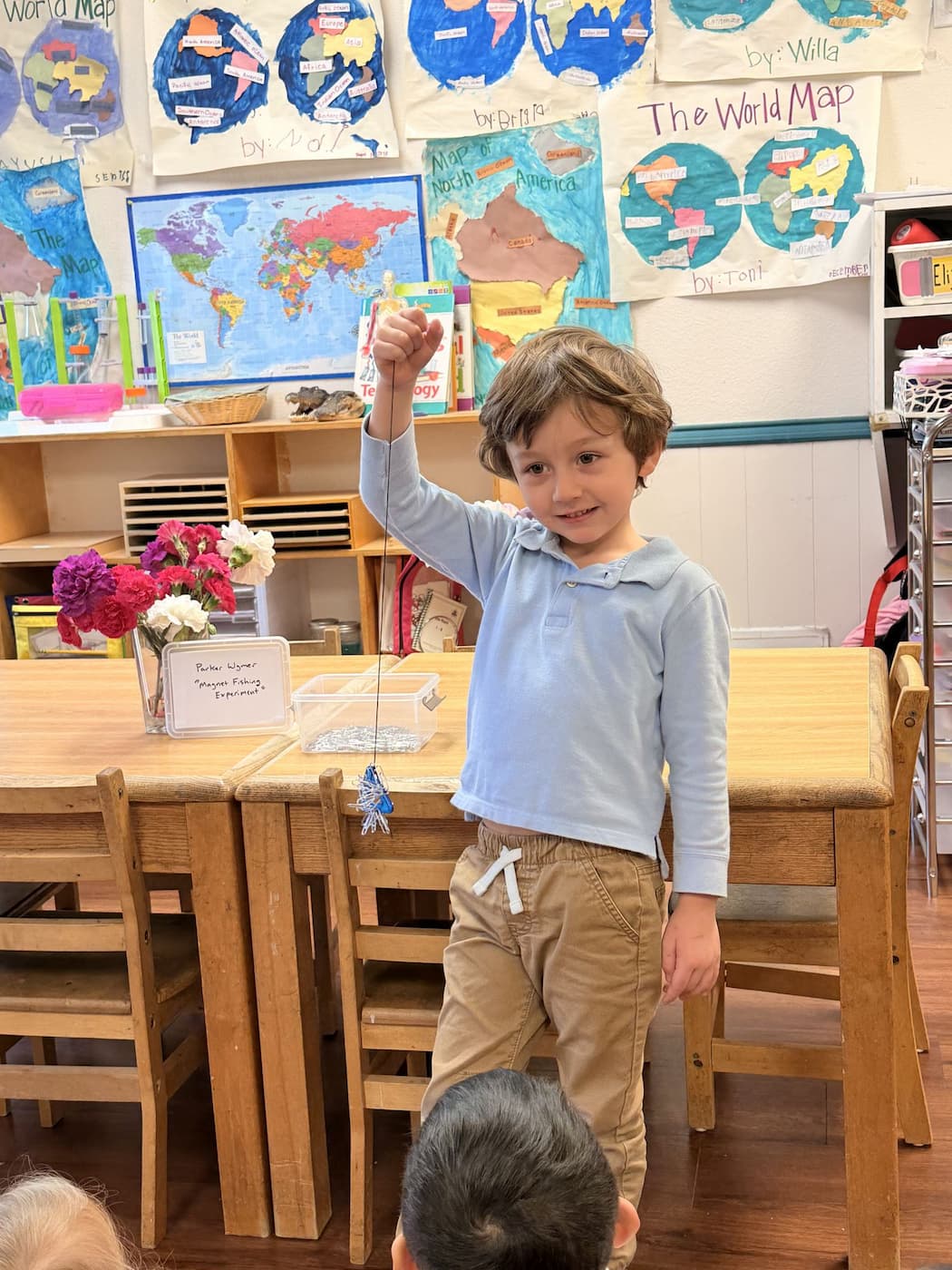 Palm Grove child completing classroom world map and science activity in Montessori learning environment