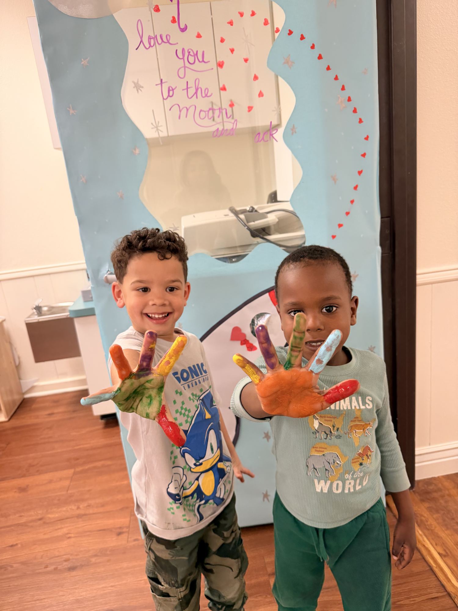 Palm Grove Plano preschool children showing colorful painted hands during creative art activity