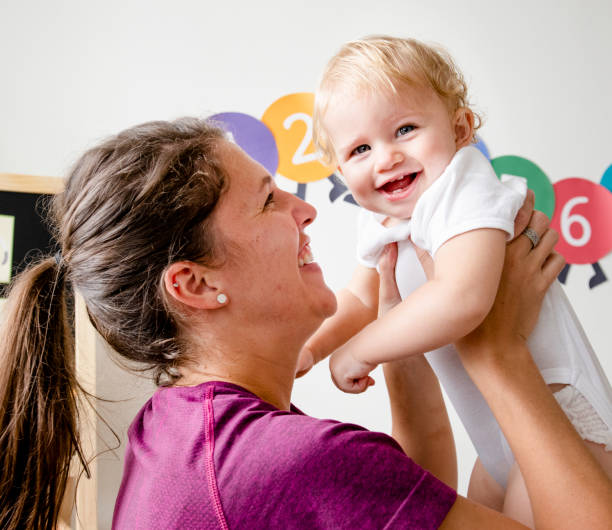 Palm Grove infant care Plano TX teacher holding baby in classroom