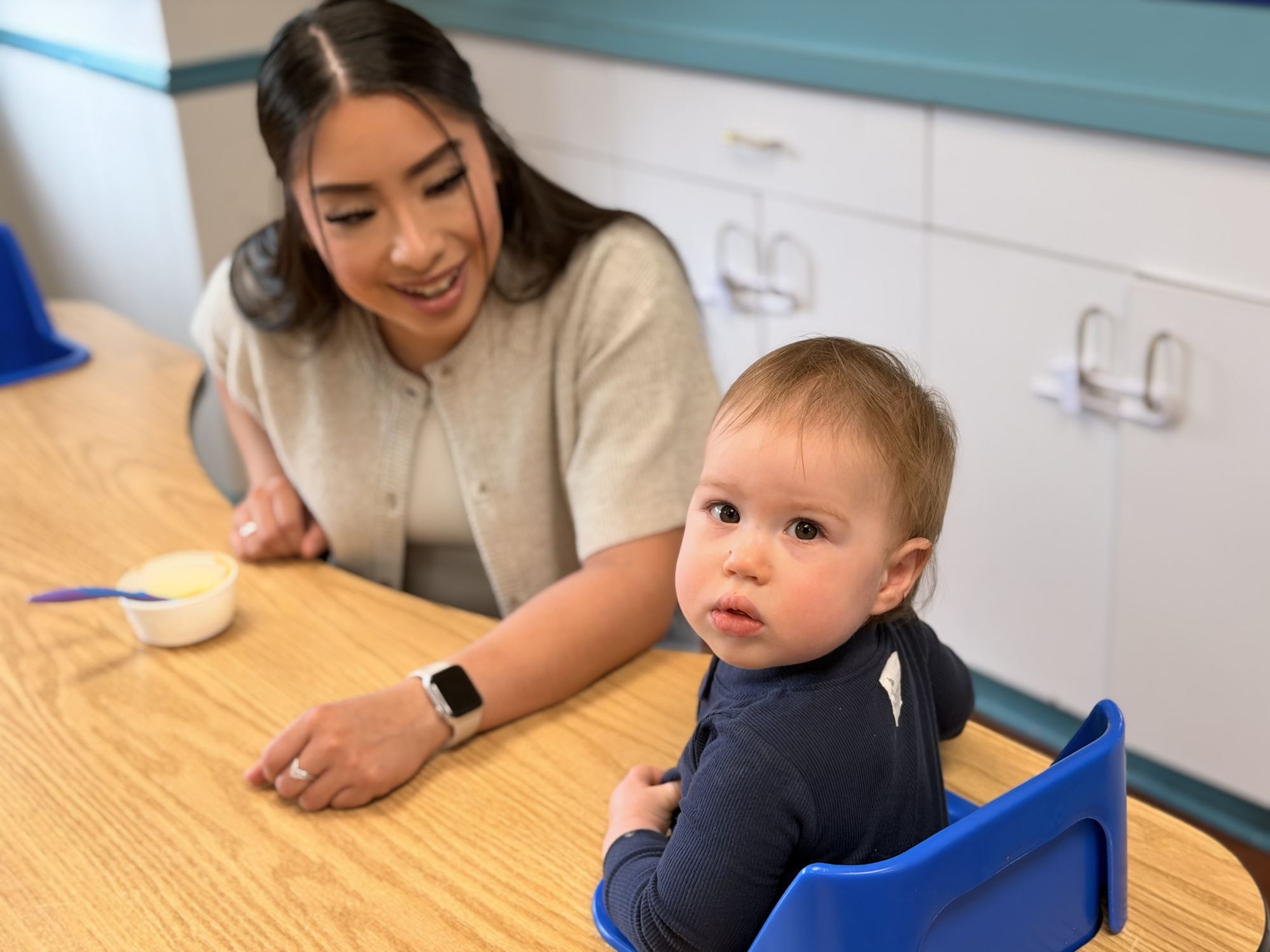 Mobile infants at Palm Grove in Plano TX with caregiver during mealtime routine