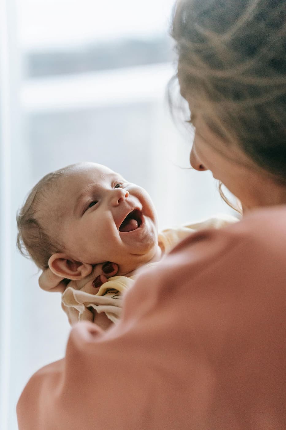 Infant daycare in Plano TX baby smiling during responsive caregiving